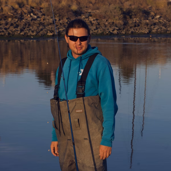 Man standing towards the camera with a fishing rod in hand