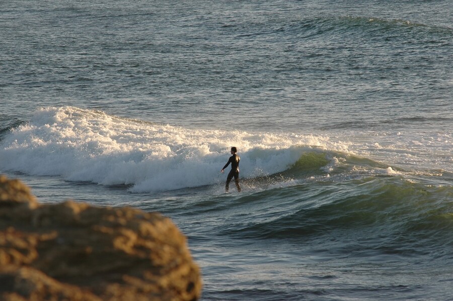 Man calmly surfing in front of a wave