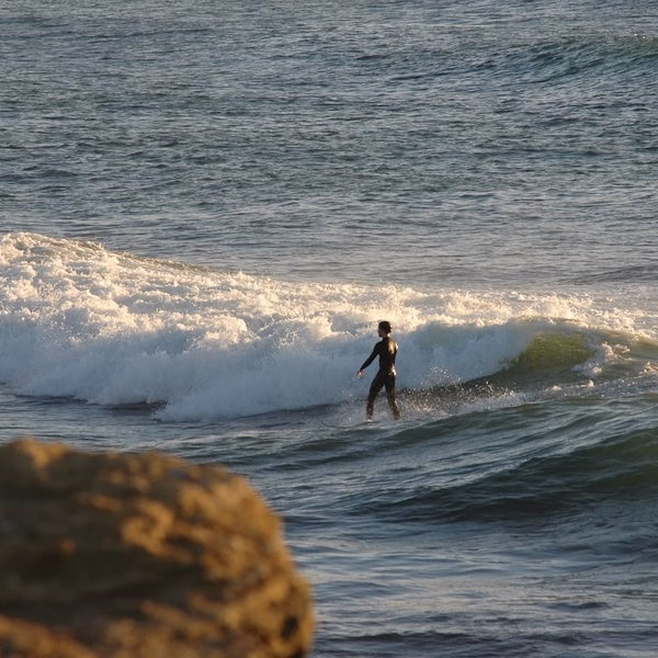 Man calmly surfing in front of a wave