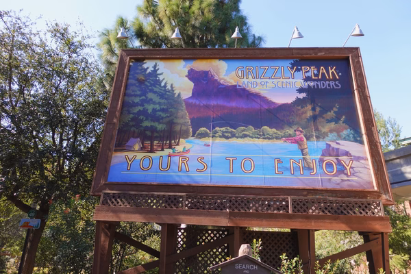 Billboard at Disney California Adventures for Grizzly Peak, with a man fishing in a river and the words Yours To Enjoy in large letters