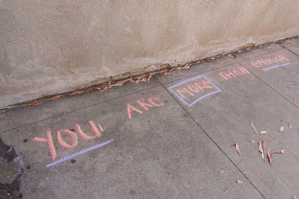 Writing in chalk on a sidewalk that says You Are More Than Enough