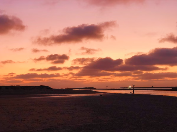 Sunset colors over a dark beach